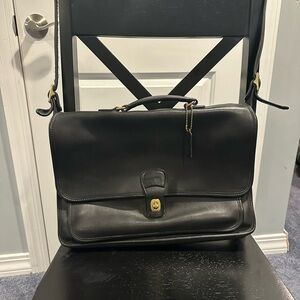 Coach Vintage 1999 black leather briefcase with adjustable strap.